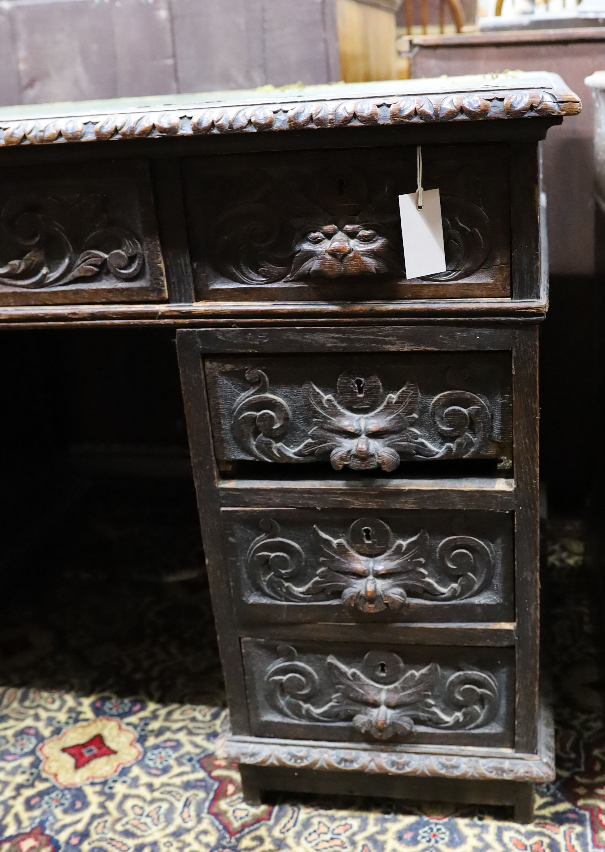 A late Victorian carved oak pedestal desk, length 121cm, depth 70cm, height 75cm